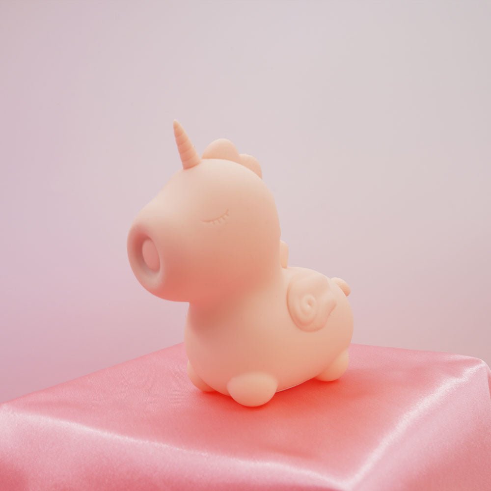Side view of the Unihorn - heart throb - pulsing clitoral stimulator, on a light pink background | Flirty Bay adult store and lingerie store